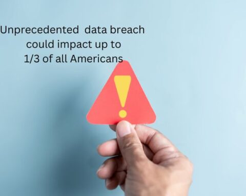 Warning sign being held, words in back ground stating "uprecedented data breach