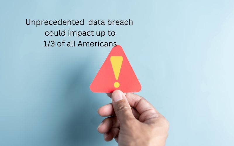 Warning sign being held, words in back ground stating "uprecedented data breach